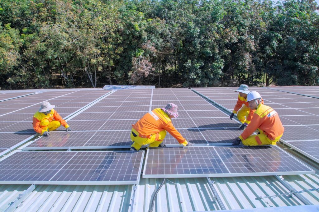 Team of workers installing solar panels on a sunny day, promoting renewable energy and sustainabilit