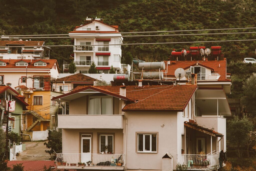 Scenic hillside neighborhood showcasing charming multi-storey homes with vibrant red roofs.
